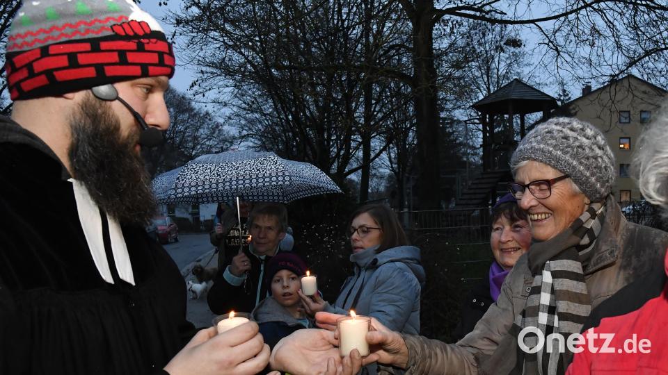 Mit kleinen Kerzen gab Pfarrer David Scherf das Friedenslicht an Anwohner und Passanten weiter. Bild: Petra Hartl