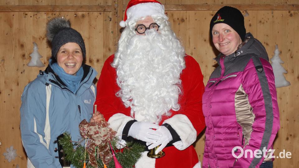 Linda Hirsch (links),, die Leiterin des Kindergartens An der Allee, freute sich über den mit Geldscheinen geschmückten Tannenzweig, den ihr der Nikolaus und die Zweite Vorsitzende des Arbeiterkameradschaftvereins, Sonja Oppermann (rechts), überreichten. Bild: mfh