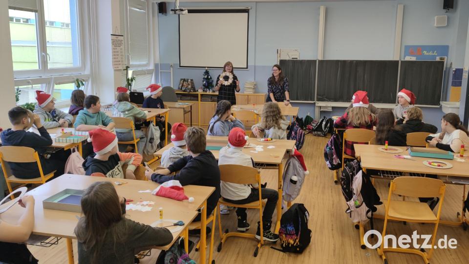 Die Schüler basteln zusammen Adventskränze aus Papier mit verschiedenen Accessoires und Dekoartikeln. Bild: Sabine Rappl/exb