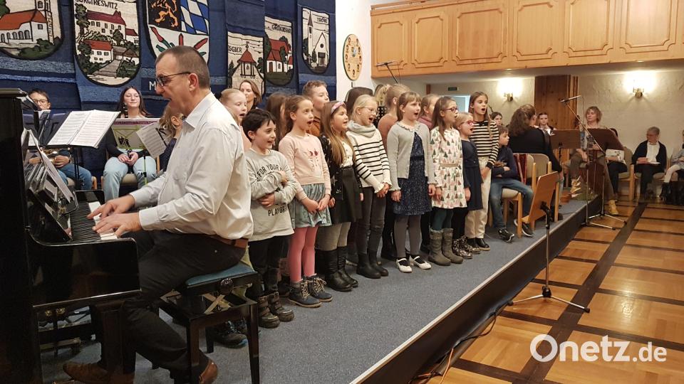 Der Schulchor begleitet von Musikschulleiter Wolfgang Ziegler am Klavier stimmte mit den „Schneeflocken“ auf die Weihnachtszeit ein. Bild: gi
