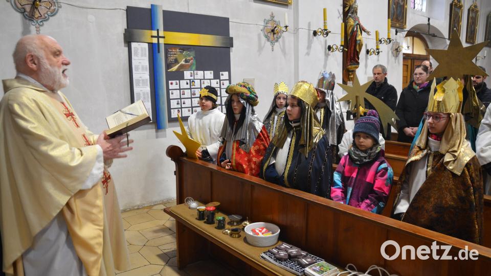 Pater Lindner segnet die Sternsinger und ihre Utensilien. Bild: fdl