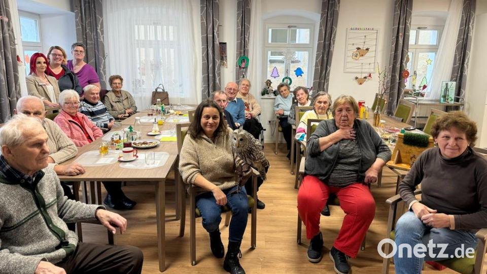 Michaela Domeyer mit Habichtskauz-Dame Birke in Mitten aller Gäste und Mitarbeiterinnen der BRK-Tagespflege d’Stawoldstubn Erbendorf. Bild: BRK Kreisverband Tirschenreuth/exb