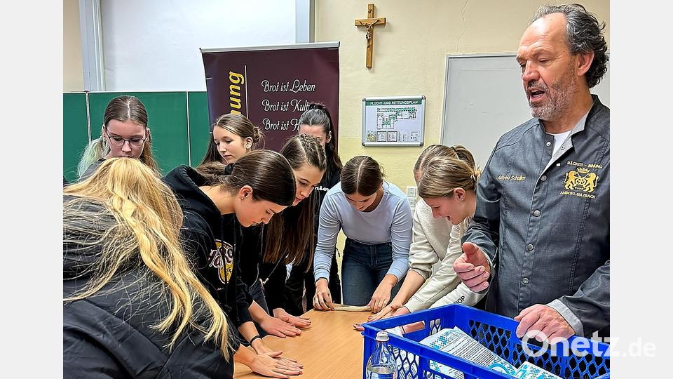 Wer eine Breze herstellen will, muss erst einmal den Teig dafür zu einem Strang rollen - mit einem dickeren Abschnitt in der Mitte. Bäckermeister Alfred Schuller hat ein Auge darauf, dass die Schülerinnen alles richtig machen. Bild: Peter Ringeisen