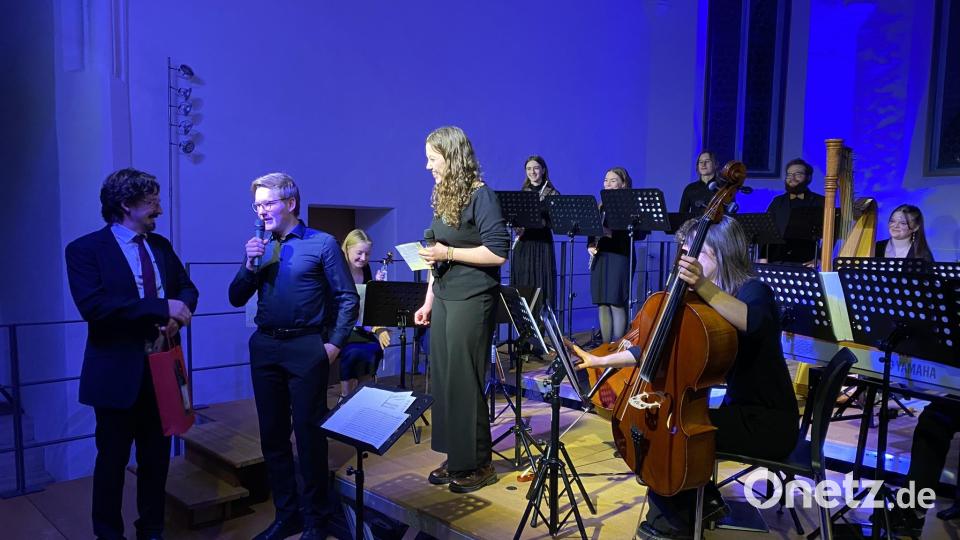 Mit einem kleinen Präsent bedanken sich die Moderatoren in Namen der Seminaristen bei Musiklehrer Stefan Schindler für dessen großes Engagement, beispielsweise mehrere Stücke passend zum Ensemble neu zu arrangieren. Bild: aub