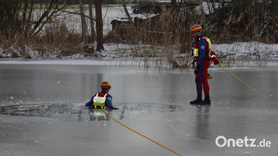 Corbinian Kraus lässt sich ins eiskalte Wasser des Eglseeweihers gleiten und stellt einen realistischen Einsatz dar. Bild: dob