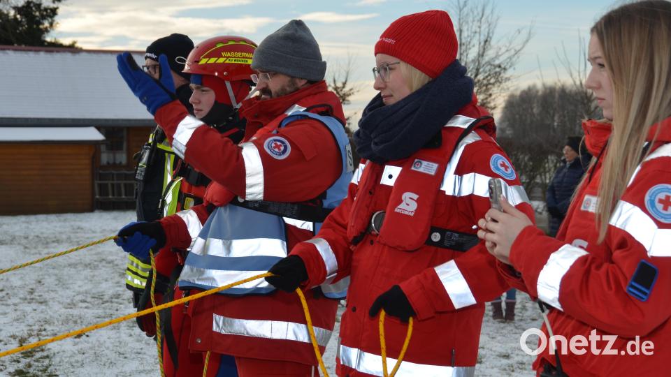 Die Mitglieder der Wasserwacht stehen am Uferrand parat zur Rückholung des Eisschlittens. Bild: dob