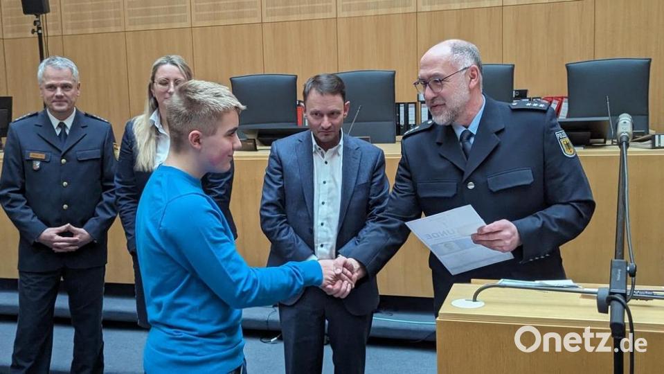Polizeihauptkommissar Josef Prill (rechts) von der Bundespolizei überreicht dem frischgebackenen &quot;Schoolguard&quot; Noah Schiml die Urkunde für seine erfolgreich abgelegte Ausbildung. Im Bildhintergrund von rechts nach links: Oberbürgermeister Jens Meyer, Eva Bühler (BRK) und Erster Polizeihauptkommissar Thomas Meiler. Bild: Bundespolizei/exb