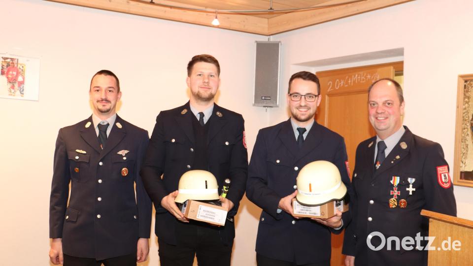 Aus den Händen der bisherigen Kommandanten Michael Vollath (rechts) und Stefan Kulzer (links) erhielten der neue Kommandant Sebastian Schwägerl (Zweiter von rechts) und sein Stellvertreter Florian Kraus (Zweiter von links) ihren Helm mit dem Zeichen für den Kommandanten und ihre digitalen Pager. Bild: Feuerwehr Beidl/exb