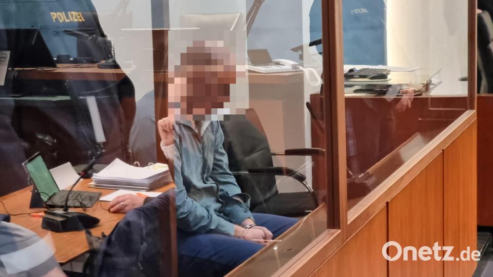 Der Angeklagte sitzt, wie die Verhandlungstage zuvor, mit gesenktem Kopf auf der Anklagebank hinter einer dicken Glasscheibe. In der Spiegelung ist sein Verteidiger Maximilian Siller erkennbar. Bild: scm