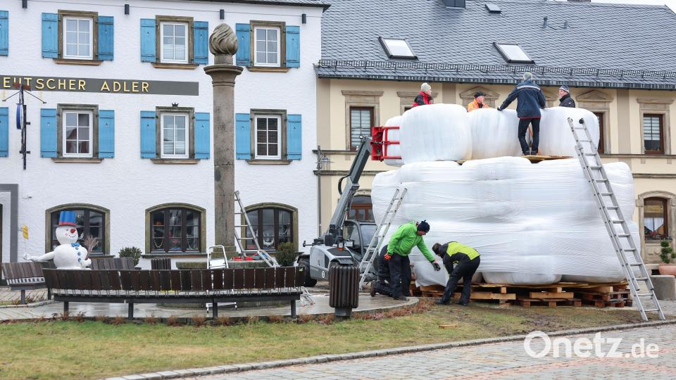 Der zwölf Meter hohe Schneemann «Jakob» steht für das Schneemannfest am Rosenmontag auf dem Marktplatz. Wegen Schneemangels verwendeten die freiwilligen Helfer dieses Mal weiße Heuballen. Der Kran bleibt aus Sicherheitsgründen stehen. Bild: Daniel Löb/dpa