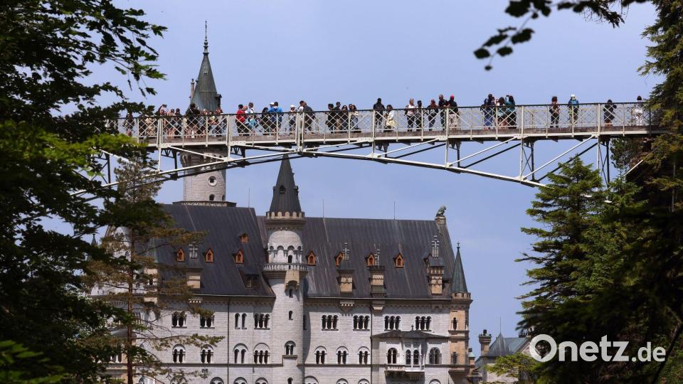 Touristen auf der Marienbrücke vor dem Schloss Neuschwanstein. Bild: Karl-Josef Hildenbrand/dpa