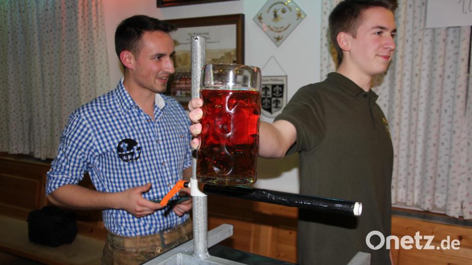 Unter den Augen von Schiedsrichter Georg Wurm (links) versuchte sich Fabian Adam beim Masskrugstemmen. Bild: kro