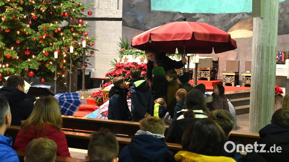 Wie geschützt man sich unter einem Sonnenschirm fühlt, dies durften die Kinder zusammen mit Lina Vicupa vom Familiengottesdienst-Team ausprobieren. Bild: kki