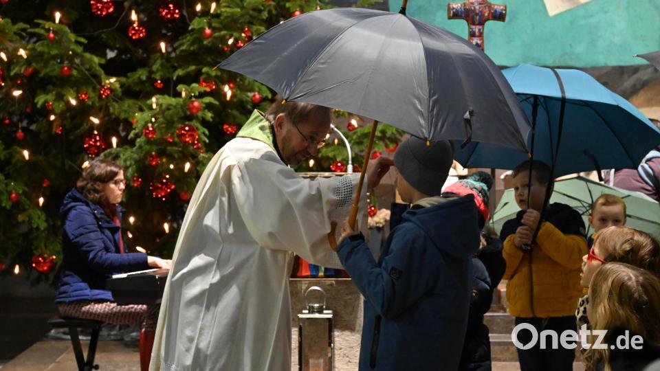 Alle Kinder durften am Ende der Andacht den Regenschirm bei Pfarrer Thomas Stohldreier gegen den Segen eintauschen und so beschirmt von Gott ins neue Jahr gehen. Bild: kki