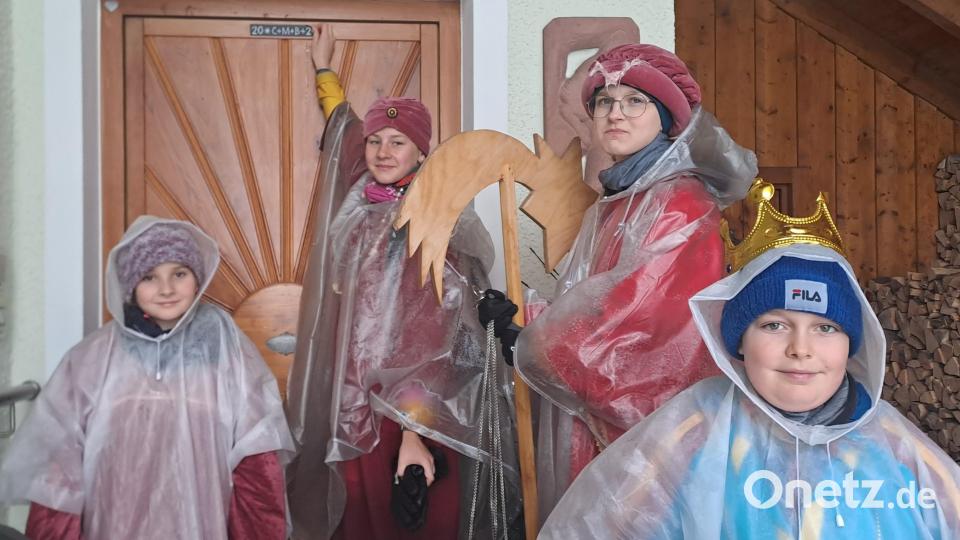 Die Sternsinger sind in Mehlmeisel und Fichtelberg bei Schnee und Regen unterwegs, im Bild eine Gruppe beim Anbringen der Segensplakette. Bild: gis/exb
