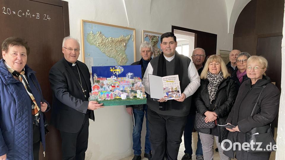 Bischof Rudolf Voderholzer (Zweiter von links) empfing die Tirschenreuther Krippenfreunde in Regensburg. Kaplan Roman Rodriguez (Sechster von rechts) überreichte dem Gastgeber eine Papierkrippe, die er im Advent mit den Kommunionkindern gebaut hatte. Rechts Vorsitzende Marianne Stangl. Bild: Pfarramt Tirschenreuth/exb