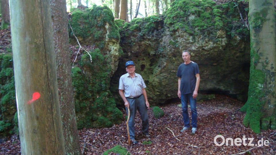 Die beiden Vettern Karl Lutter (links) und Hermann Schmaußer (rechts) erforschten gemeinsam mit Josef Schmaußer, Heimatpfleger der Gemeinde Ursensollen, die Geschichte um den „Board Hortl“, der bis circa 1960, in der kleinen Höhle am „Korlfelsen“ (Hintergrund) am alten Kirchensteig von Ehringsfeld nach Götzendorf hauste. Bild: schß