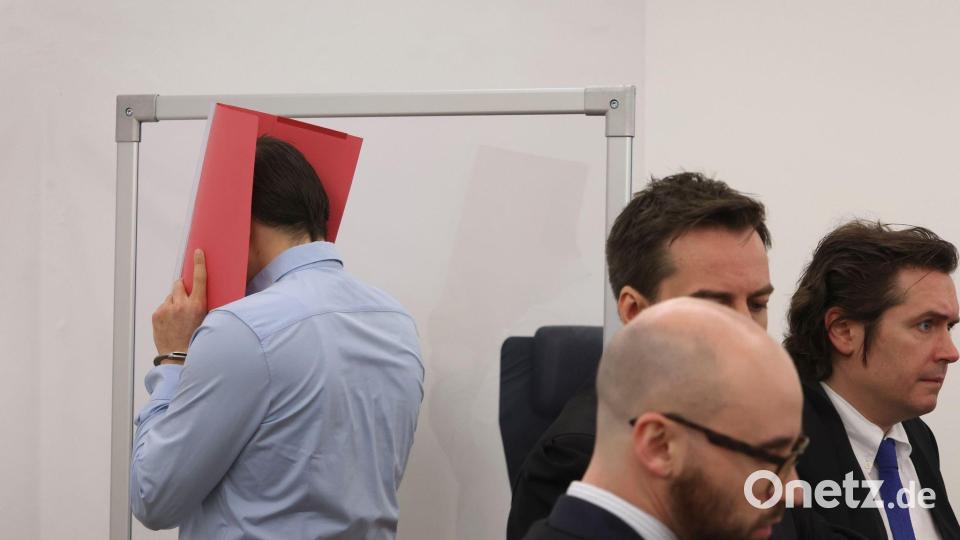 Der wegen Mordes angeklagte US-Amerikaner steht in einem Gerichtssaal im Landgericht Kempten hinter seinen Rechtsanwälten in der Anklagebank. Bild: Karl-Josef Hildenbrand/dpa