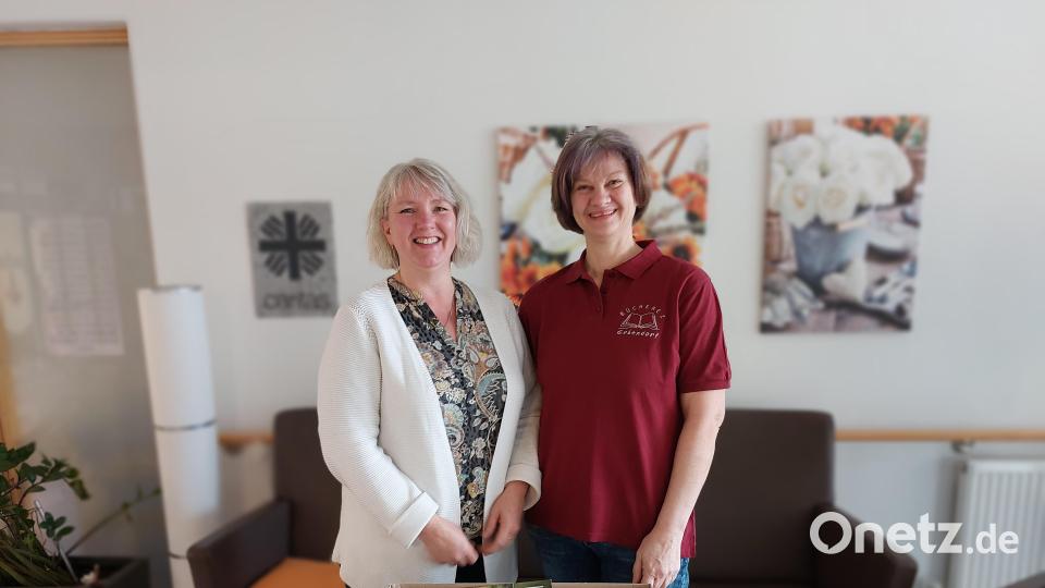 Stellvertretende Büchereileiterin Gisela Wenning bei der Übergabe der Bücherkiste an die Mitarbeiterin vom Vorzimmer des Caritas-Alten- und Pflegeheims St. Marien in Erbendorf. Bild: Anita Benkhardt/exb