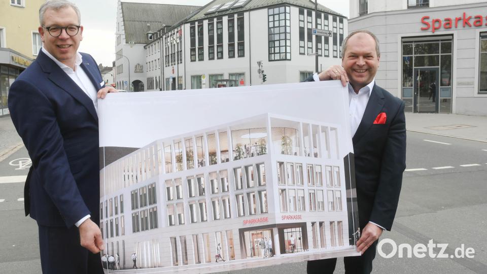 Sie haben große Pläne: Vorstandsvorsitzender Hans-Jörg Schön (rechts) und Vorstandsmitglied Jens Michael Heine zeigen den ersten Architektenentwurf für die neue Fassade der Hauptstelle am Sparkassenplatz. Im Hintergrund ist das Gebäude mit seiner aktuellen Ansicht zu sehen. Bild: Gabi Schönberger