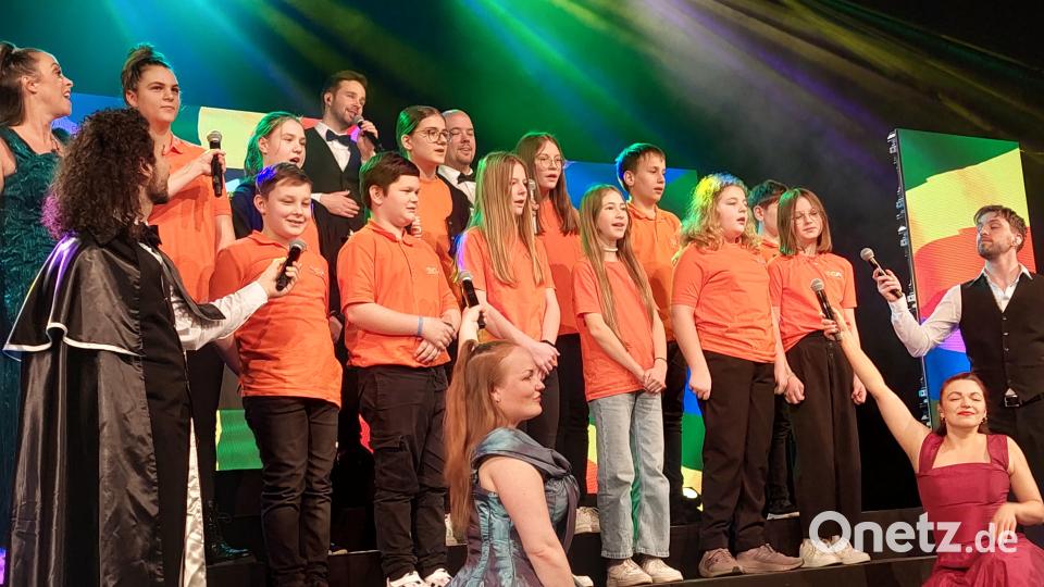 Großer Auftritt auf der Musical-Bühne in der Schwarzachtalhalle: Der OGO-Unterstufenchor aus Oberviechtach darf in seinen orangefarbenen Shirts bei &quot;The World of Musicals&quot; mitsingen. Bild: jua