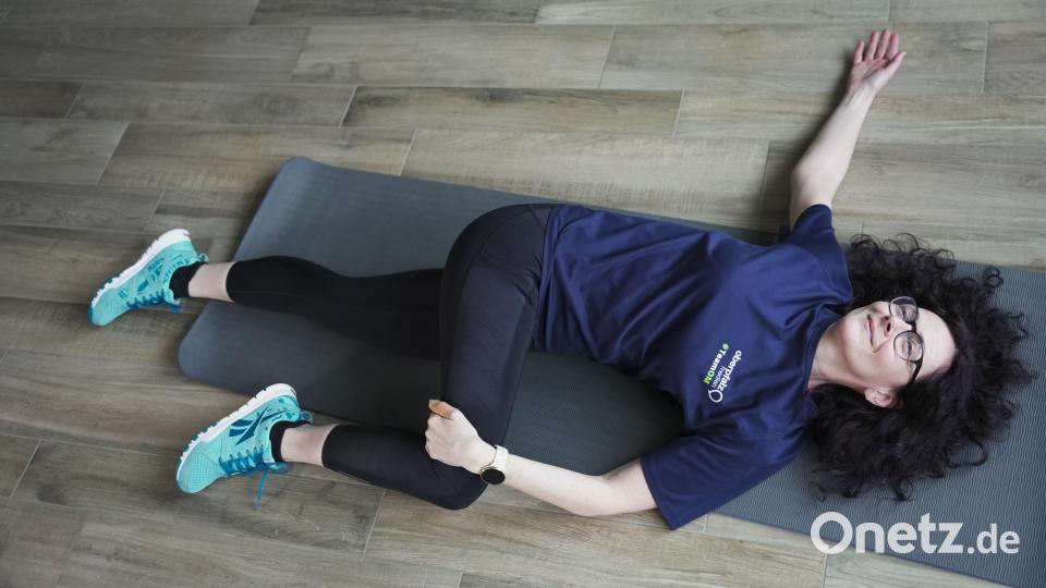 Auf den Rücken legen, ein Bein anwinkeln und mit dem Arm auf die gegenüberliegende Seite drücken. Den anderen Arm seitlich wegstrecken.
 . Bild: Dominik Mark