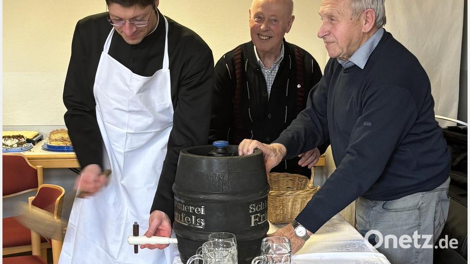 Gekonnt wurde das Fass von Pfarrer Gierl (links) mit drei Schlägen angezapft. Vorsitzender Franz Völkl (Zweiter von links) und Ernst Luk (rechts) beobachten das Geschehen. Bild: cro