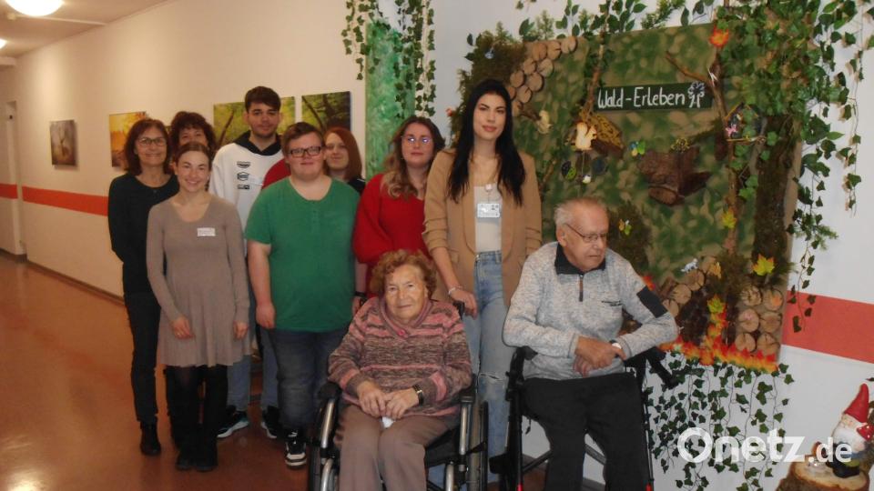 Den Azubis der Berufsfachschule für Pflege des Klinikums St. Marien gelang es gemeinsam mit vier Bewohnern des BRK-Pflegeheims St. Barbara eindrucksvoll auf einer Sinneswahrnehmungswand das Thema „Wald-Erleben“ darzustellen. Stehend v. l.: Schulleiterin Karin Meixner, Lehrerin Monika Fajkis-Sobestjanski, Heimleiterin Astrid Geitner, die Azubis Denis Savu, Jan Mayer, Lara Wehner, Marina Berndt und Milena Pieler. Sitzend v. l.: Inge Döring und Heinz Adam. Bild: u