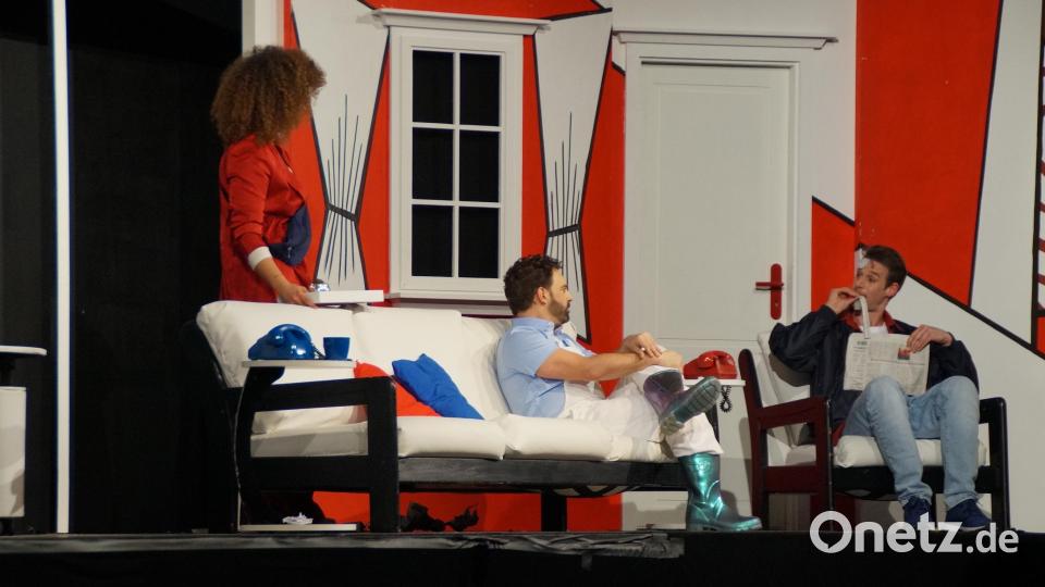 Aus lauter Verzweiflung isst John (rechts) die Seite der Tageszeitung, auf der über seinen Unfall berichtet wird. Ehefrau Barbara und der Nachbar (von links) sollen das nicht lesen. Bild: wel