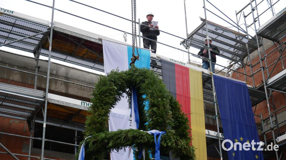 Polier Markus Hammerl (links) und der gebürtige Waldsassener Peter Seidel, beide von der Generalbaugesellschaft Mickan, beim Richtspruch, während ein Baukran die festlich geschmückte Richtkrone emporhob. Bild: hmr