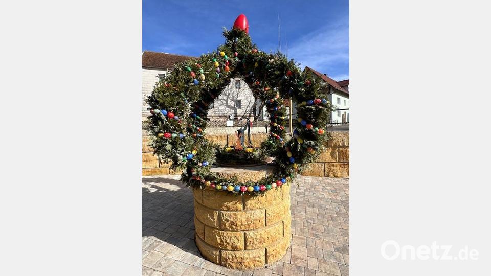 Mit geschickten Händen fertigt die Dorfgemeinschaft Sassenreuth erstmalig eine Osterkrone am Brunnen. Bild: exb; Janine Hoffmann