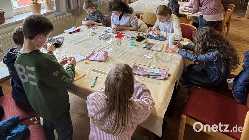 Noch einen Silberfaden hier und ein Glitzersteinchen dort und die bunt geschmückten Osterkerzen der Kinder waren fertig Bild: cro