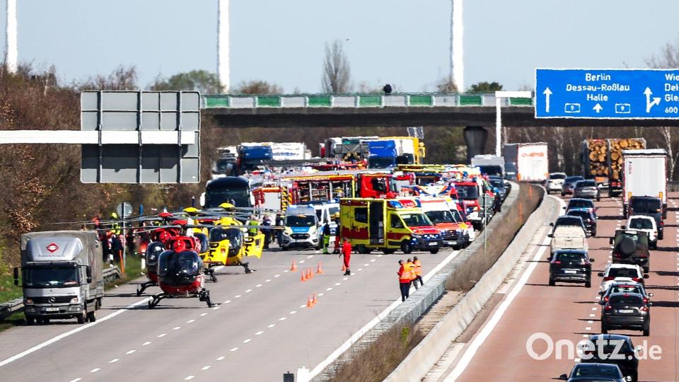 Einsatzfahrzeuge und Rettungshubschrauber stehen auf der A9 an der Unfallstelle. Bild: Jan Woitas/dpa