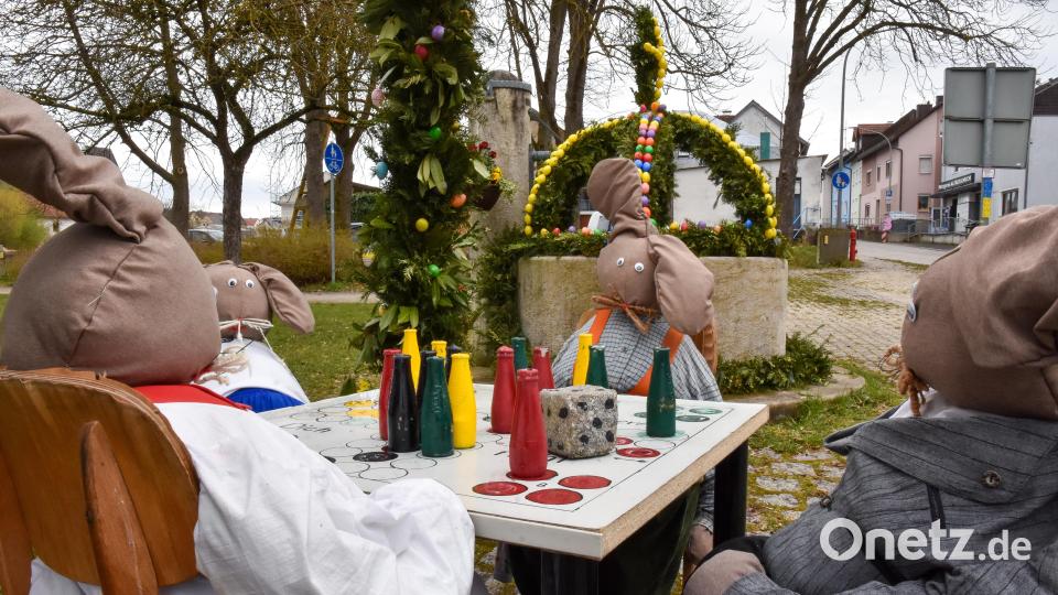 Am Osterbrunnen in Raigering spielen Osterhasen &quot;Mensch ärgere dich nicht&quot;. Der Obst- und Gartenbauverein Raigering-Aschach hat sich diese Szene ausgedacht. Bild: Stephan Huber