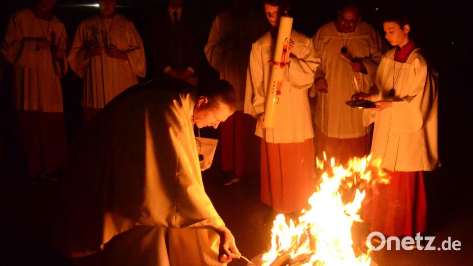 Pfarrvikar Reinald Bogensperger entzündet am Osterfeuer die Osterkerze. Bild: Kunz