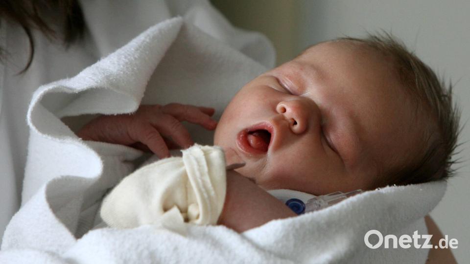 Ein Neugeborenes ruht auf diesem Symbolbild im Arm einer Schwester. 292 Geburten verzeichnete das Krankenhaus Tirschenreuth im Jahr 2023. 52 Kinder folgten in den letzten drei Monaten der Geburtshilfestation. Symbolbild: Federico Gambarini/dpa