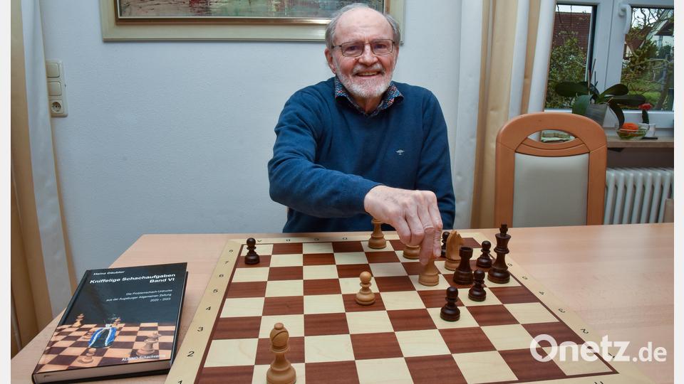 Heinz Däubler am Brett mit einem Schachproblem, das er zum 100-jährigen Bestehen des Schachclubs Furth im Wald 2022 komponiert hat. Links sein neues Problemschach-Buch. Bild: Stephan Huber