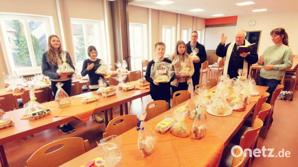 Pfarrer Erwin Bauer segnet im Beisein von Kirchenpflegerin Nicola Hummer, Pfarrgemeinderat Bernd Reil und einigen Minis die Osterprodukte. Bild: gz