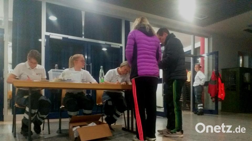 Kurz vor 23 Uhr registrieren sich am Mittwoch die ersten Bewohner aus dem Evakuierungsgebiet in der Trimax-Halle in Amberg, die ihr Quartier für die Nacht wird. Wie lange sie bleiben müssen, ist zu diesem Zeitpunkt noch unklar. Bild: Thomas Kosarew