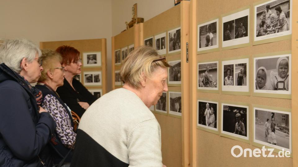 In kleinen Gruppen schauen sich die Schirmitzer Bürgerinnen und Bürger die Bilder der Ausstellung genauestens an, um sich vielleicht selbst oder andere Freunde darauf zu entdecken. Bild: bey