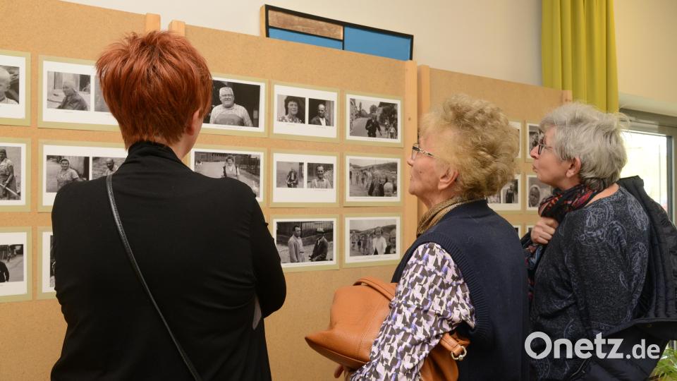 In kleinen Gruppen schauen sich die Schirmitzer Bürgerinnen und Bürger die Bilder der Ausstellung genauestens an, um sich vielleicht selbst oder andere Freunde darauf zu entdecken. Bild: bey