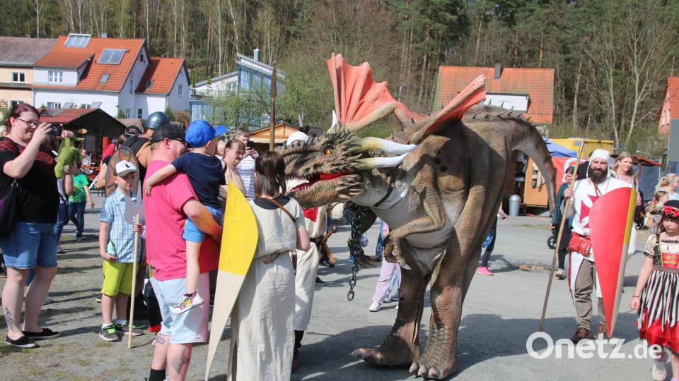 Wenn der Drache an Ketten über den Platz geführt wird, folgen ihm Kinder und Erwachsene mit Handy-Kameras. Bild: sne