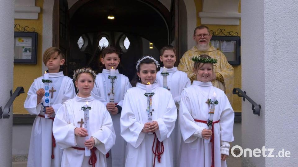 Die Erstkommunionkinder (vorne, von links) Lena Riedel, Luisa Klement und Christin Rauch sowie (hinten, von links) Remus Küffner, Maximilian Friedrich und Lukas Protschky mit Pfarrer Robert Ploß. Bild: R. Müller/exb