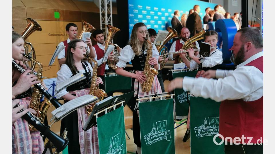 Die Stadtkapelle spielt die Hymnen, die CSU-Funktionäre auf der Bühne singen mit. Bild: Portner