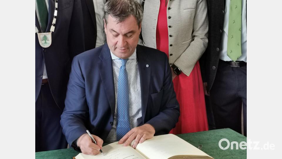 Ministerpräsident Markus Söder schreibt eine persönliche Widmung in das Goldene Buch der Stadt. Bild: Portner