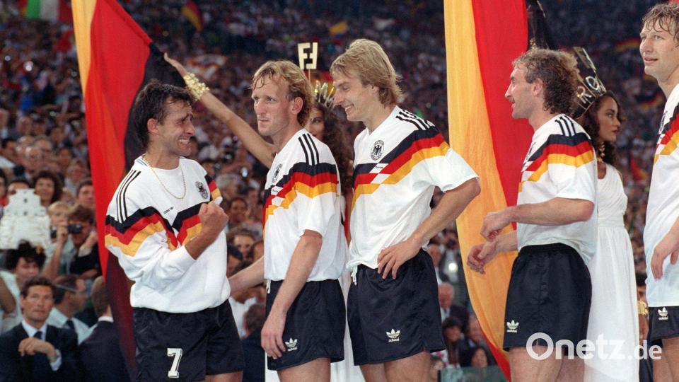 Pierre Littbarski (l-r), Andreas Brehme, Jürgen Klinsmann, Rudi Völler und Guido Buchwald erwarten im Olympiastadion von Rom vor ihrer Landesfahne stehend die Siegerehrung der Fußball-Weltmeisterschaft. Bild: Frank Leonhardt