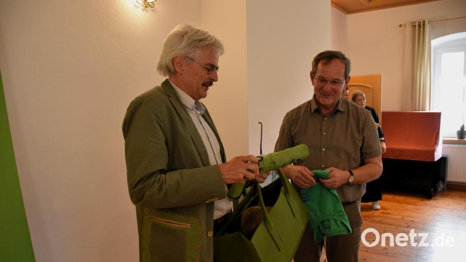 Landesvorsitzender Richard Mergner hatte für den BN-Vorsitzenden Werner Schubert (v. links) ein &quot;Überlebenspaket&quot; in Form eines BN-Shirts, eines Regenschirms und eines Stofftier-Bibers als Geschenk dabei. Bild: ubb