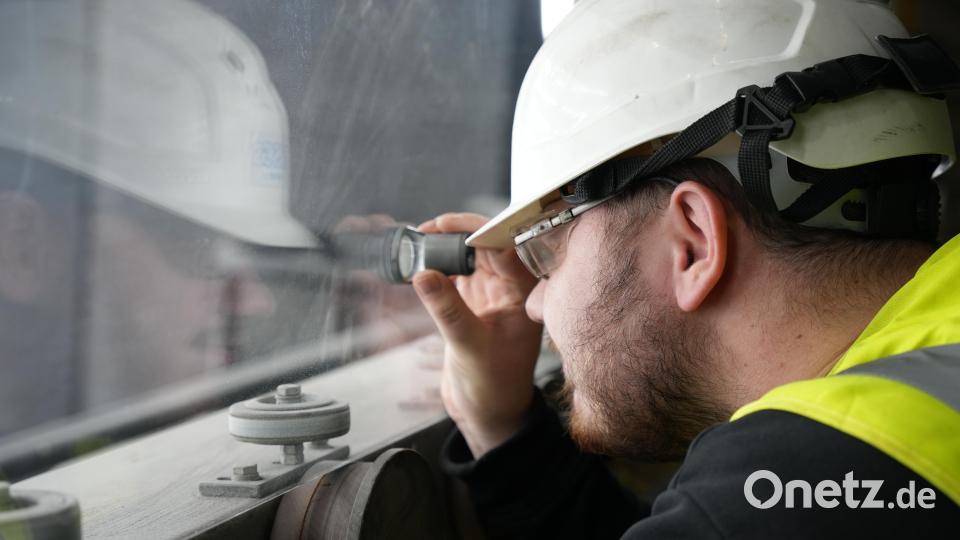 Ein Mitarbeiter überprüft das frisch hergestellte Glas in Weiherhammer Bild: Sebastian Böhm