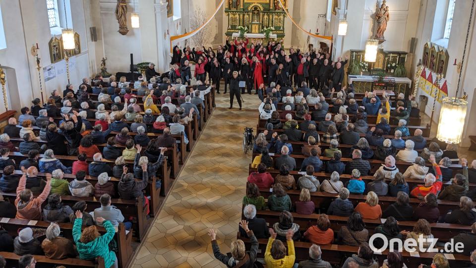 Beim Schlusslied &quot;We are the World&quot; recken sich die Arme der Chormitglieder und des Publikums schwenkend nach oben Bild: eib