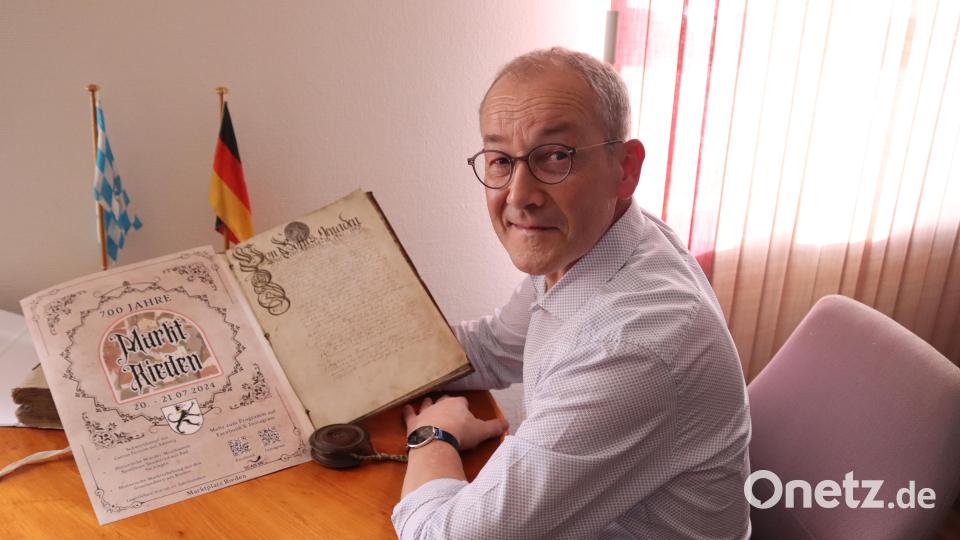 Bürgermeister Erwin Geitner präsentiert das historische Dokument aus dem Jahr 1735 (rechte Seite), dazu das aktuelle Werbeplakat zur 700-Jahr-Feier des Marktes Rieden (linke Seite). Bild: mrr